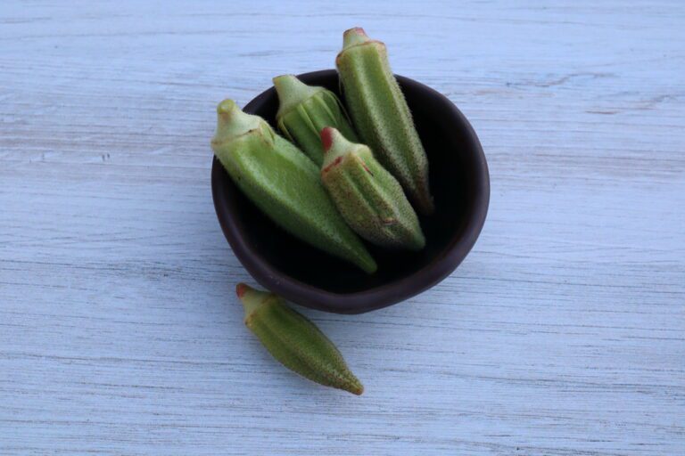 Çiçek okra pods photographed in a small clay bowl and backdrop with wood pattern.