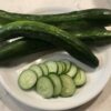 Sliced and whole Kelahmet Long cucumbers displayed in a white plate