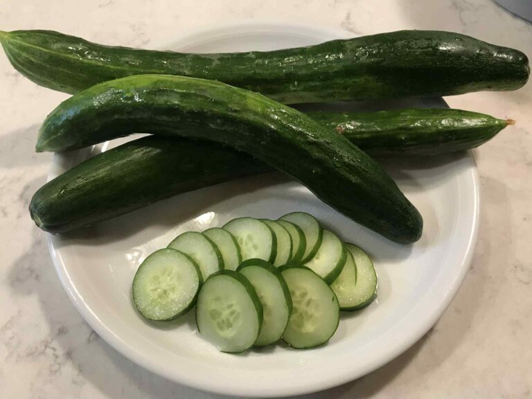 Sliced and whole Kelahmet Long cucumbers displayed in a white plate