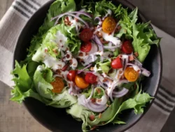 Fresh salad with cherry tomatoes, red onion and Reine de Glaces iceberg lettuce leaves