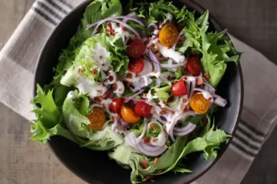 Fresh salad with cherry tomatoes, red onion and Reine de Glaces iceberg lettuce leaves