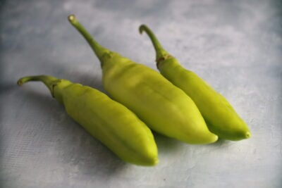IMG_2124 Three Pestişori Ciorbagiu peppers photographed on photography backdrop with concrete texture.