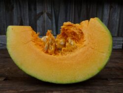 Mature Adapazarı winter squash slice pictured on wooden box.