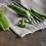 Sultani pea seeds and pods pictured on washcloth and photography background.